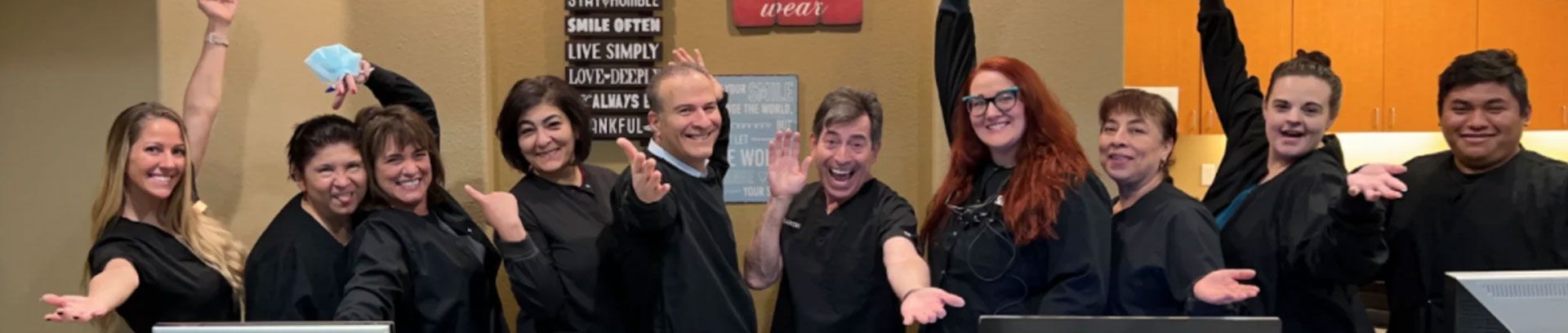 The A Great Smile Dental team waving in the office